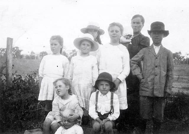 A group of children in front of a fence, early 20th century